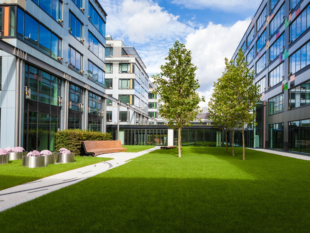 A large building with a lush green lawn in front of it.