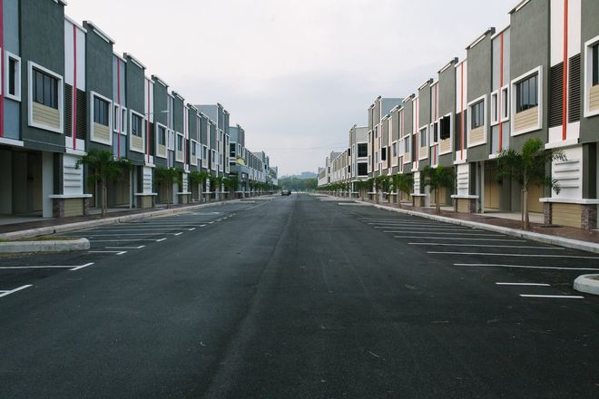 An empty street with a row of buildings on both sides for HOA pest control