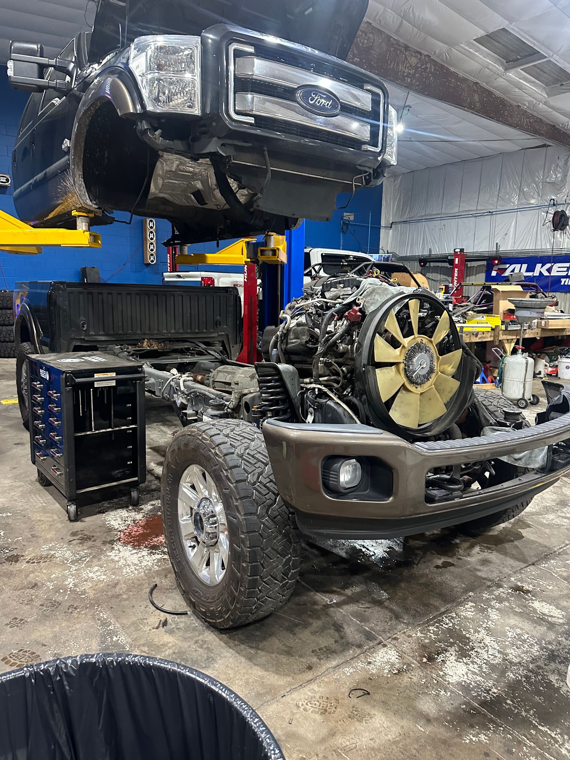 A truck in a garage with the front end and engine removed; the truck sits on a lift | Marshside Motors