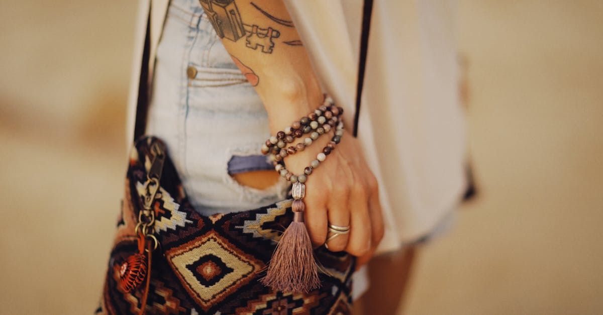 A woman with a tattoo on her arm is holding a purse.