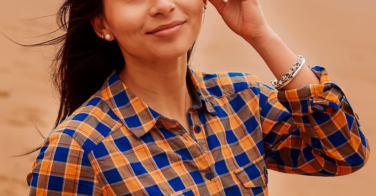 The woman is wearing a plaid shirt and a bracelet.