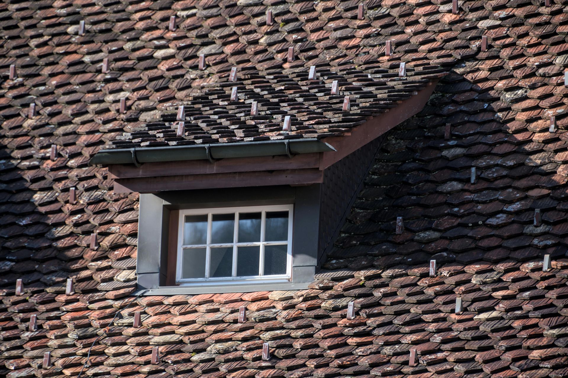 Dormer window with white frame on a red-tiled roof