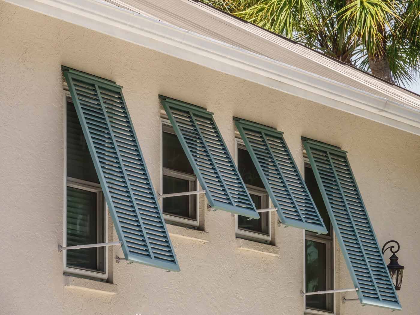 A white house with blue shutters on the windows