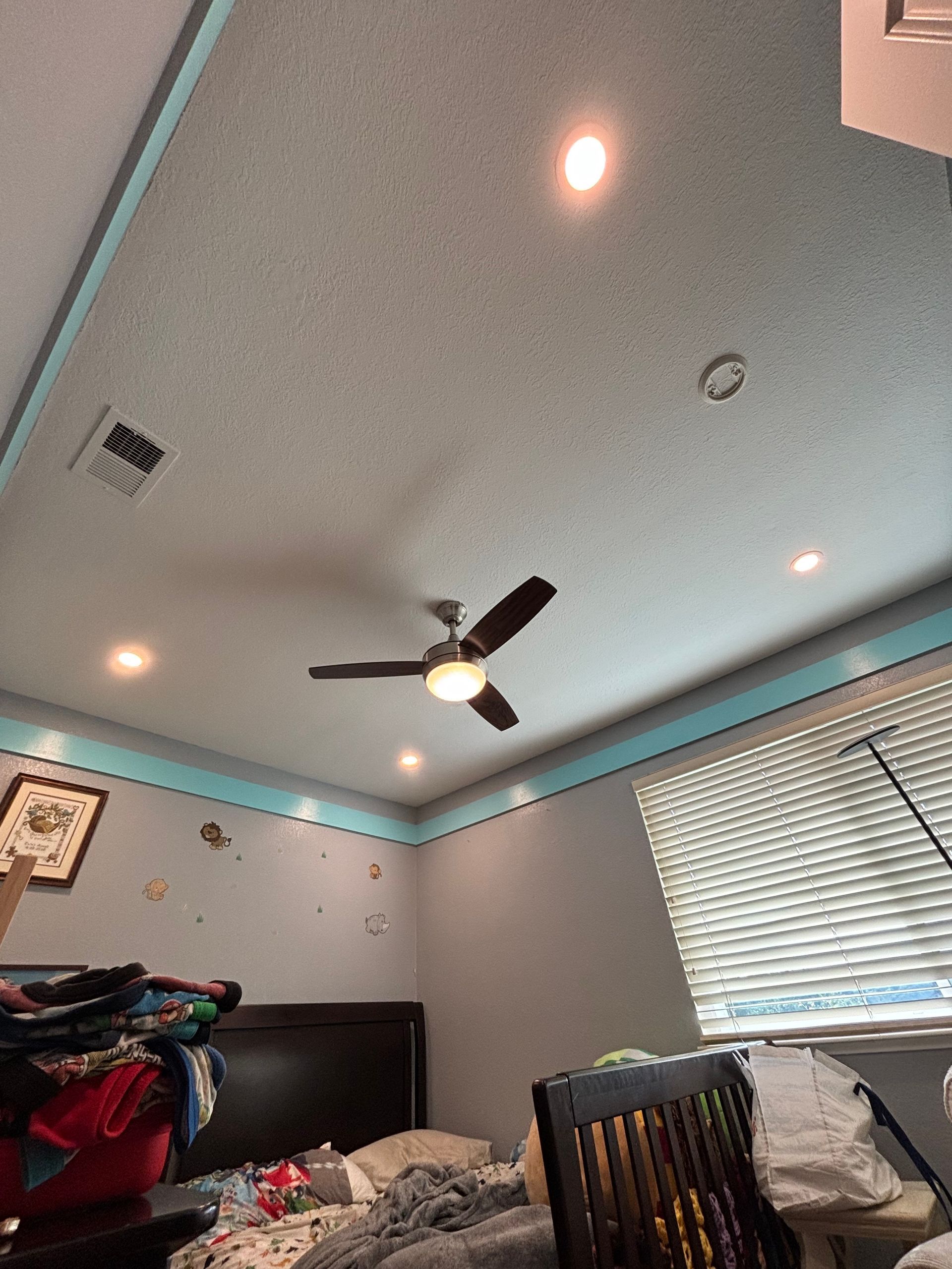 Bedroom ceiling with recessed lights, ceiling fan, and blue trim.