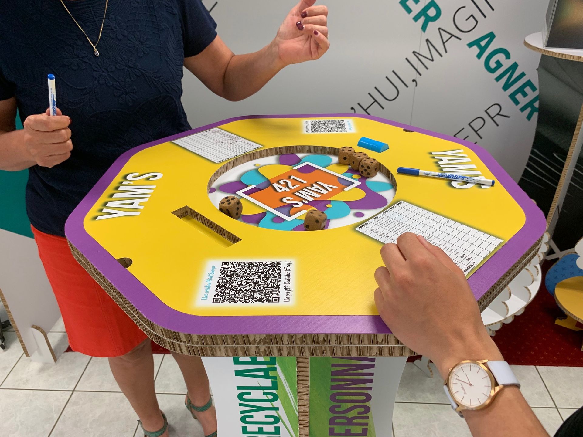 Une personne portant une montre joue à un jeu sur une table en carton