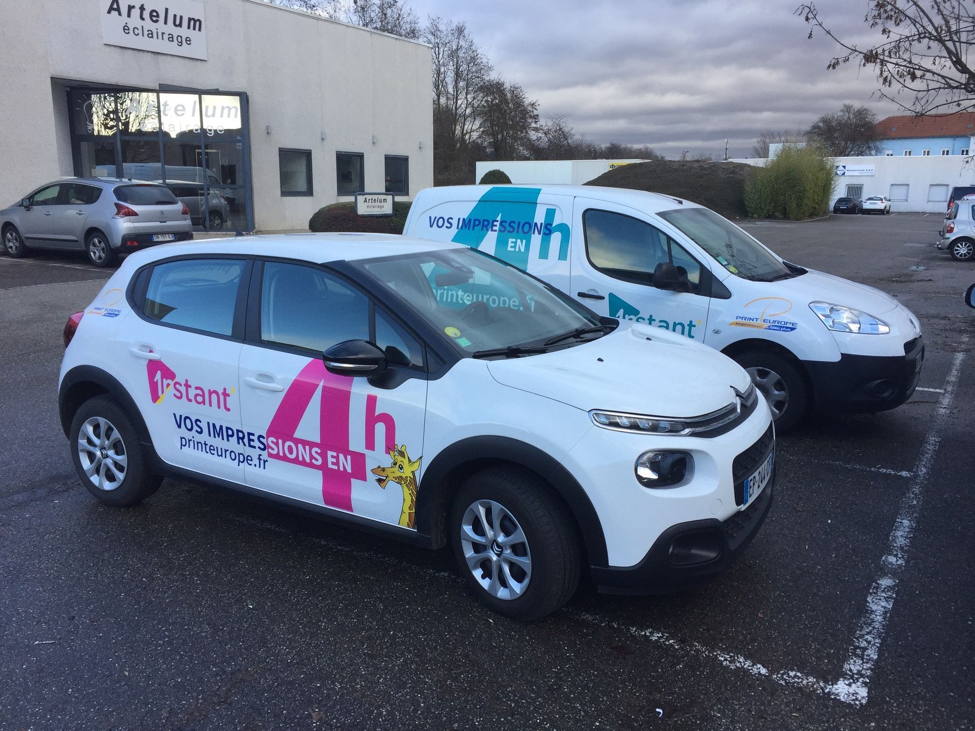 Deux voitures blanches sont garées l'une à côté de l'autre sur un parking.