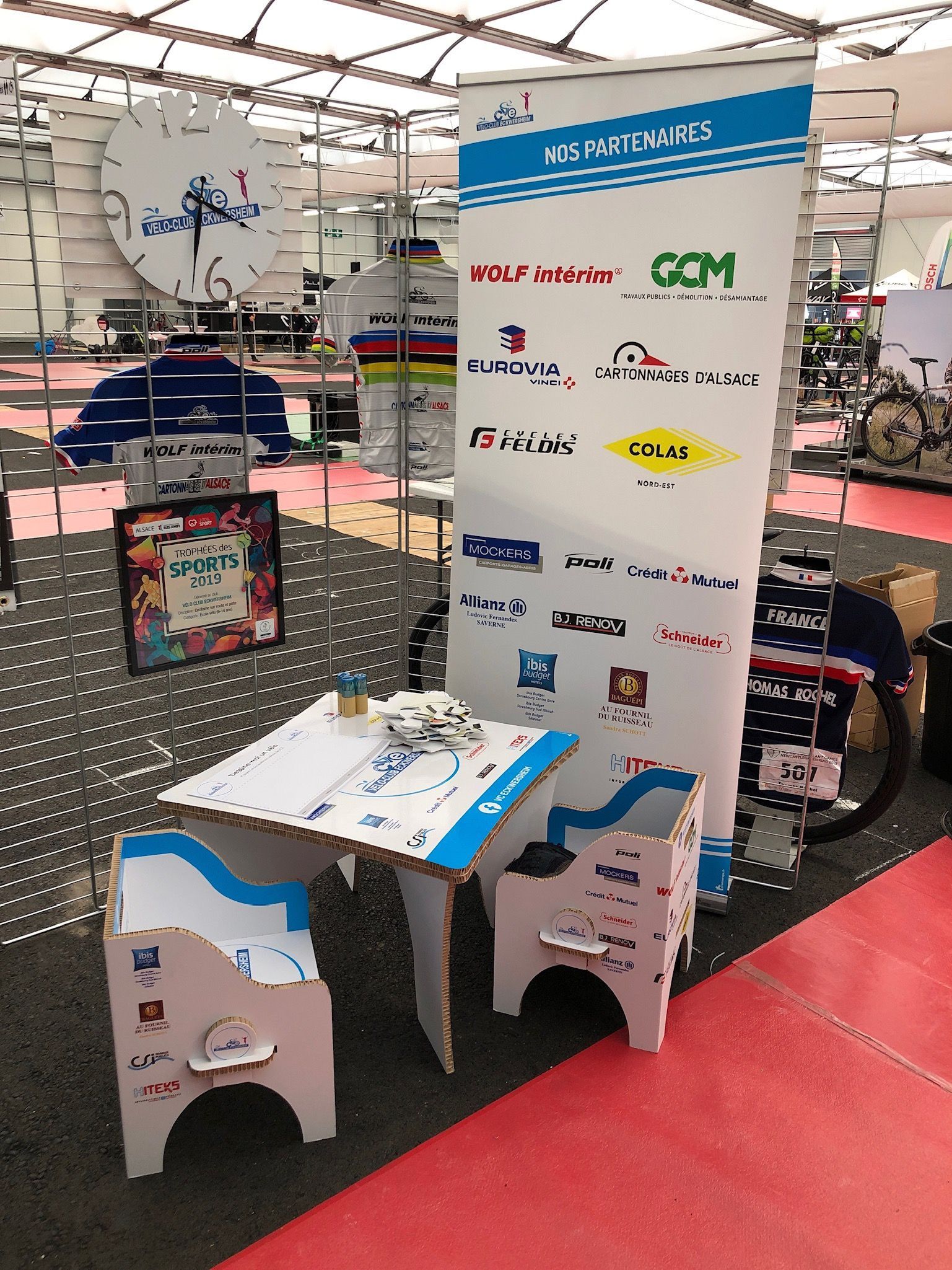 Une table et des chaises devant un panneau indiquant com