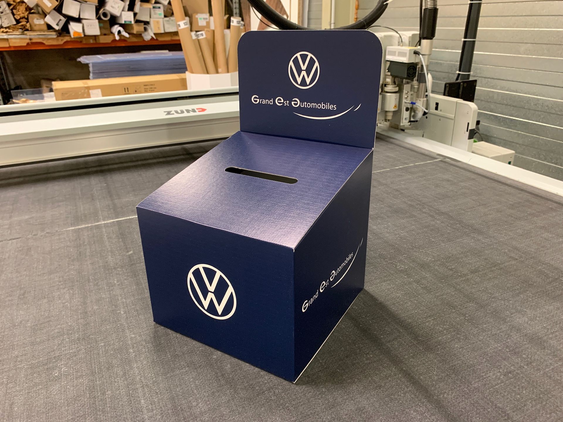 Une boîte bleue avec un logo VW dessus est posée sur une table.