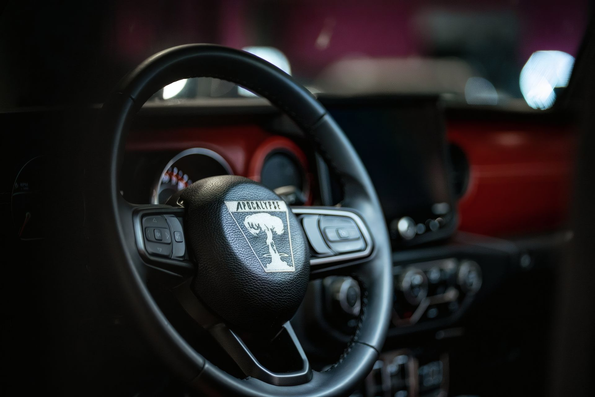 Close-up of a steering wheel and dashboard inside a red car interior