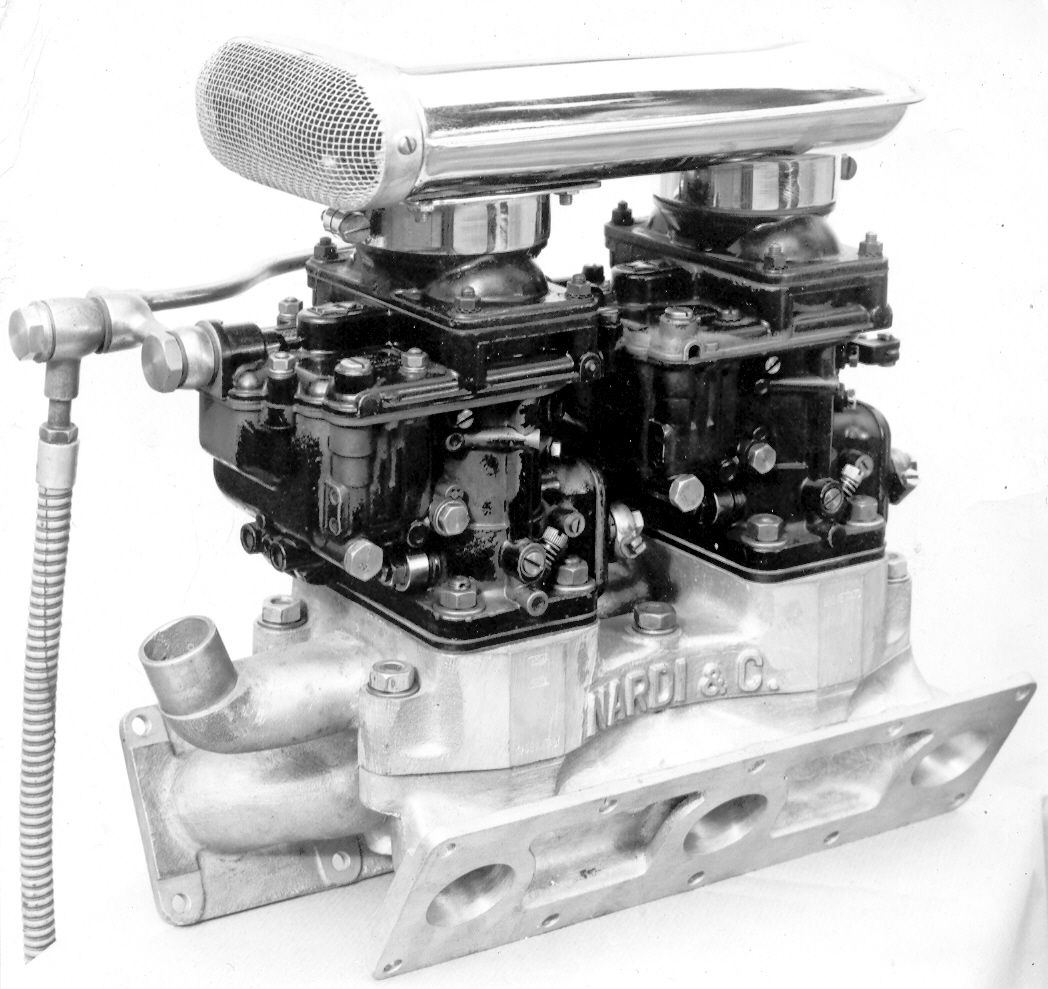 Engine with dual carburetors and a distinctive air filter, mounted on a metal intake manifold.