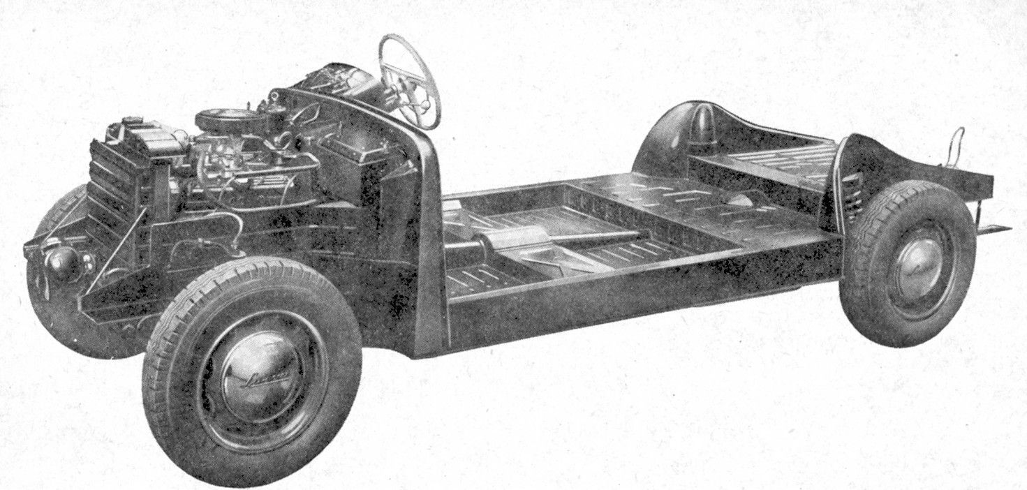 Black and white photograph of a car chassis with the engine visible.