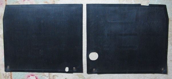 Two black rubber floor mats with vertical ribbed texture and a few holes.