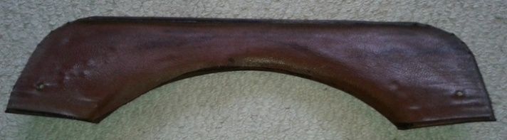 Dark brown, curved metal car fender.