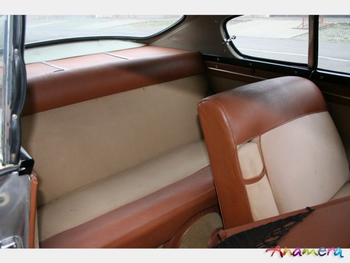 Interior of a classic car: tan and brown leather seats.