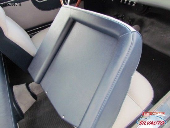 Blue car seat with a white seat next to it, set in a car.