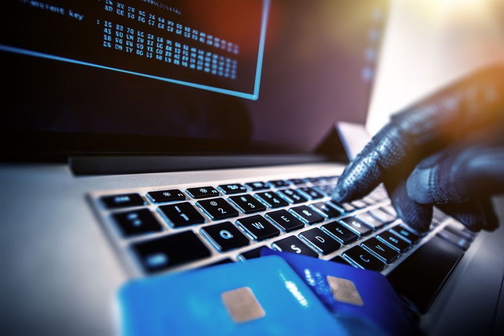 A Person Is Using A Laptop Computer With A Credit Card On The Keyboard — Surveillance NQ In Aitkenvale, QLD