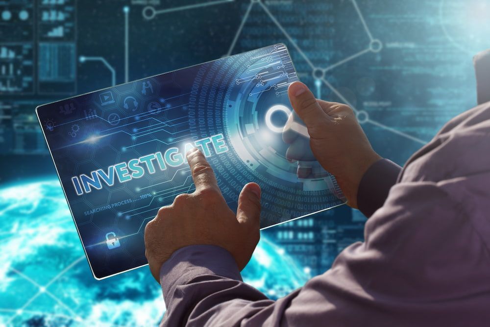 A Man Is Holding A Tablet With The Word Investigate On It — Surveillance NQ In Aitkenvale, QLD