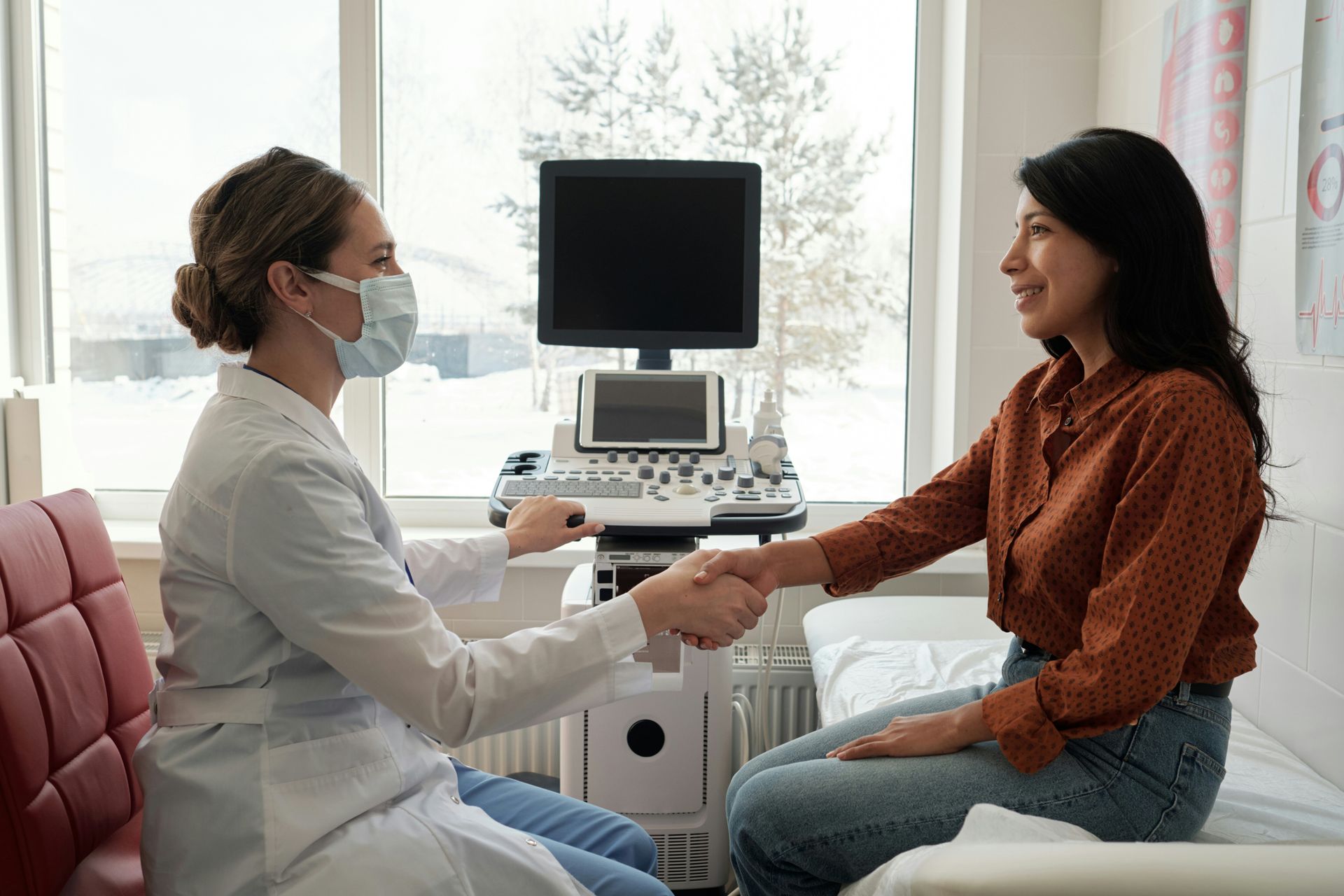 Clinician taking a patient’s pulse during an exam in a medical office