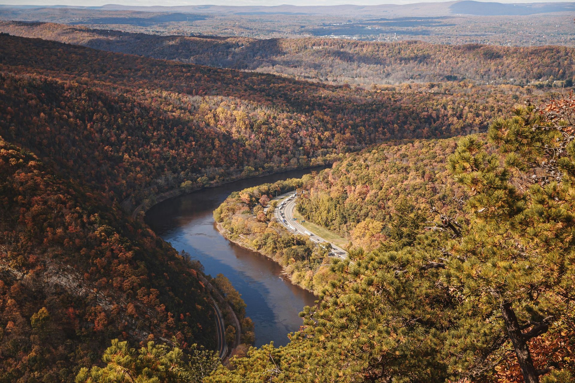 Autumn forested canyon with a winding river under a hazy sky