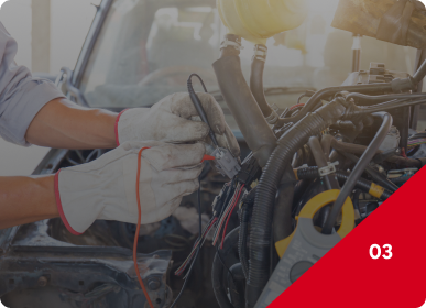 Mechanic’s gloved hands repairing engine wiring in a car’s open hood compartment | Frisco Automotive & Transmission