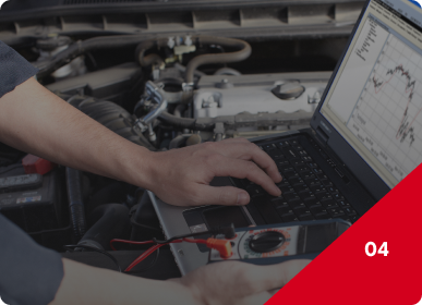 Mechanic using a laptop with diagnostic graph beside an open car engine in a garage | Frisco Automotive & Transmission
