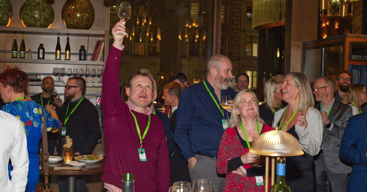People in a restaurant raise drinks and smile during a celebration