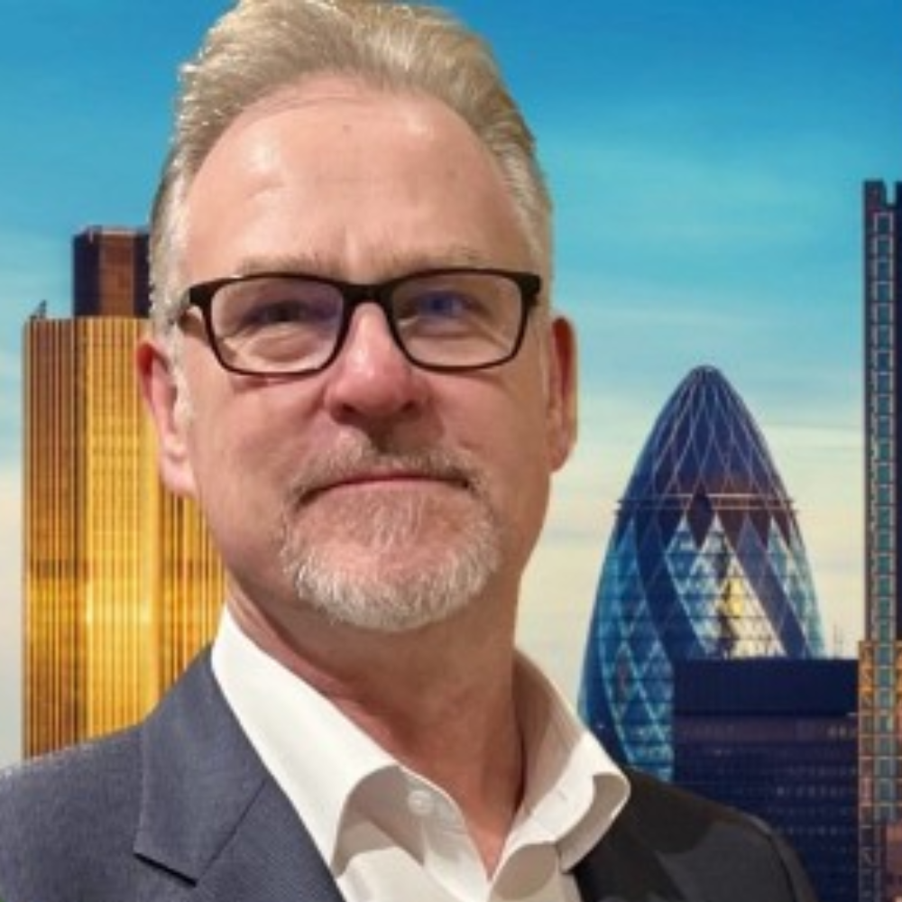 Portrait of a man in glasses and blazer with a city skyline backdrop