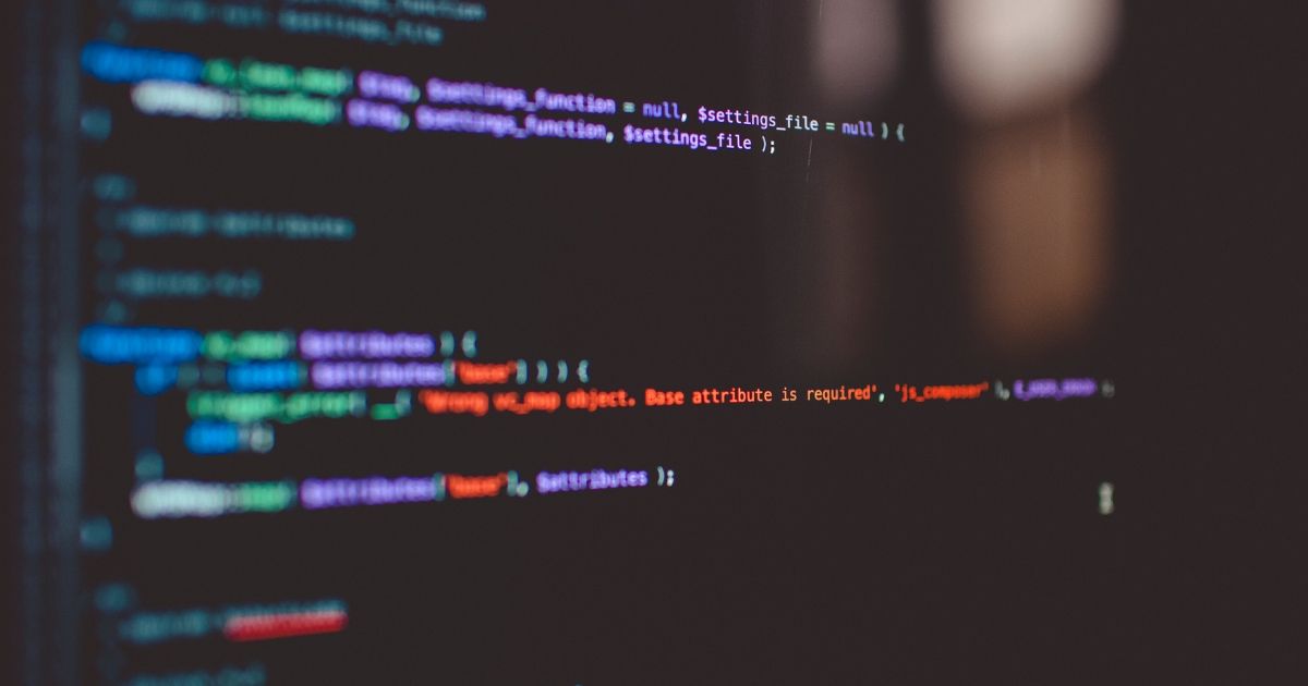 Blurred close-up of colorful programming code on a dark computer screen