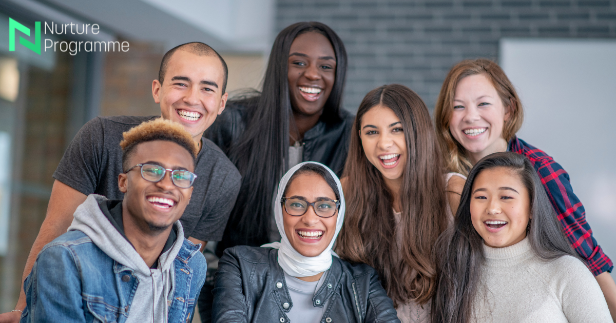 Seven smiling people posing together indoors, with a “Nursing Programme” logo in the top left.
