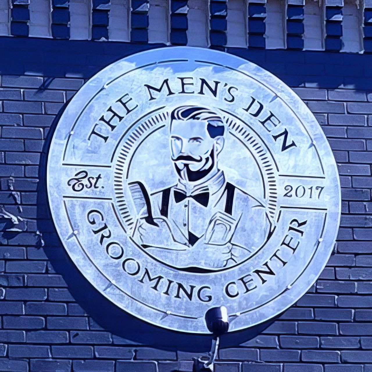 A sign for the men 's den grooming center