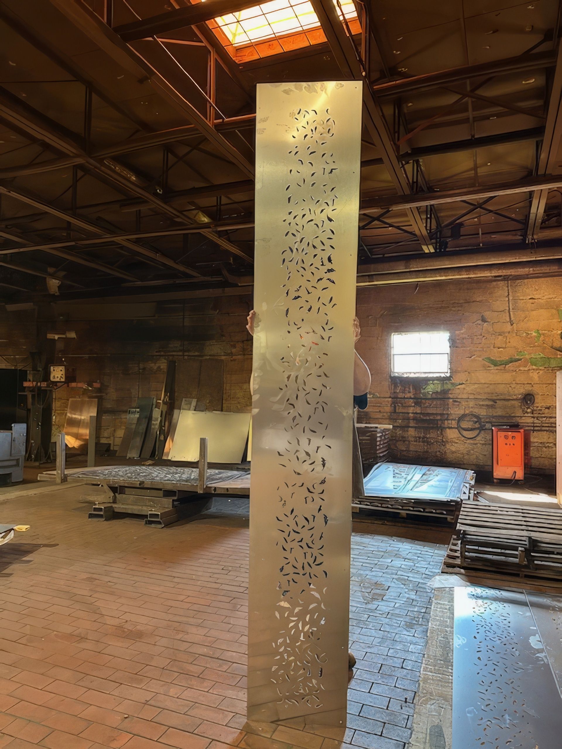 A large metal pillar with holes in it is in a warehouse