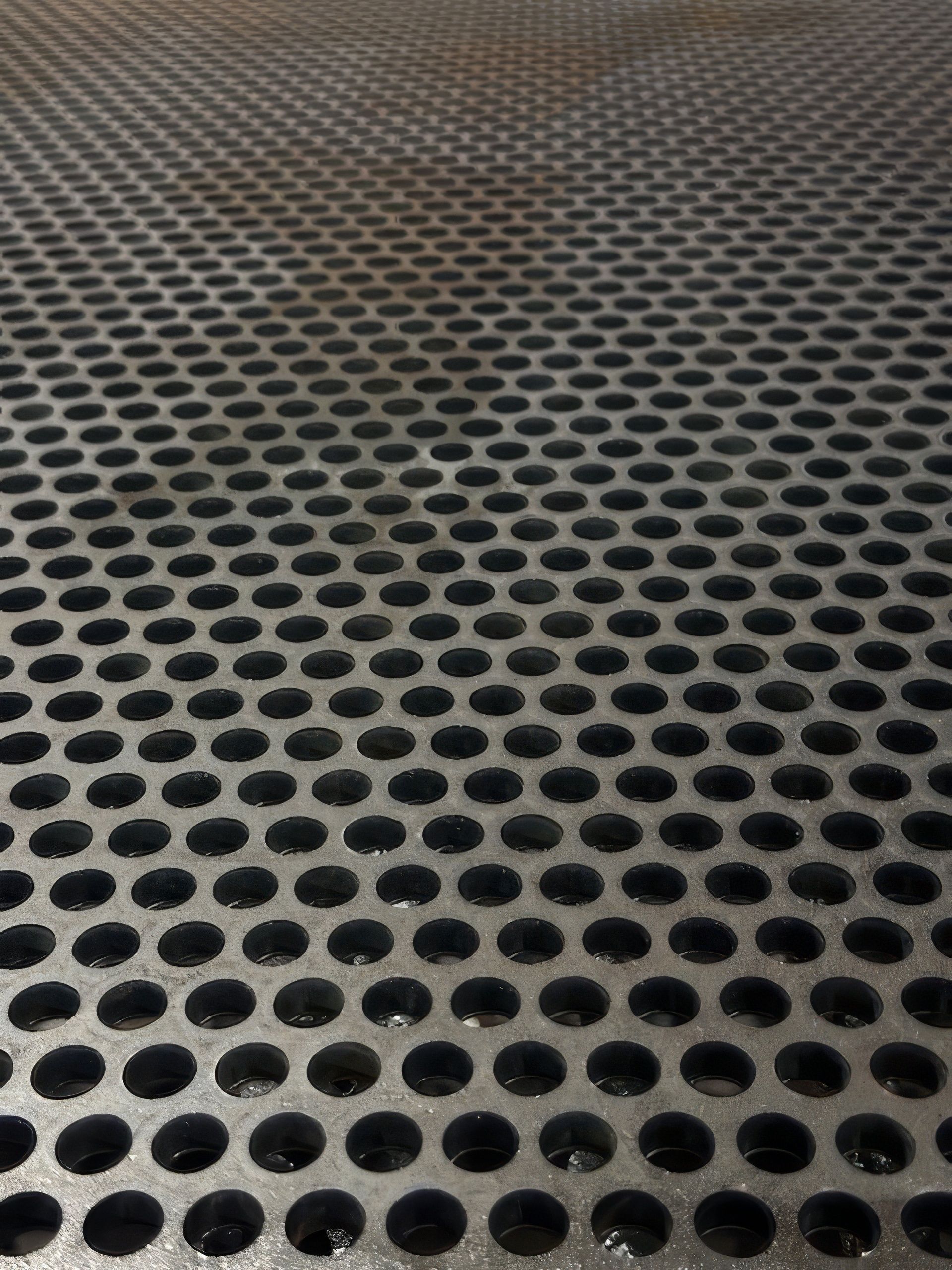 A close up of a metal surface with holes in it.