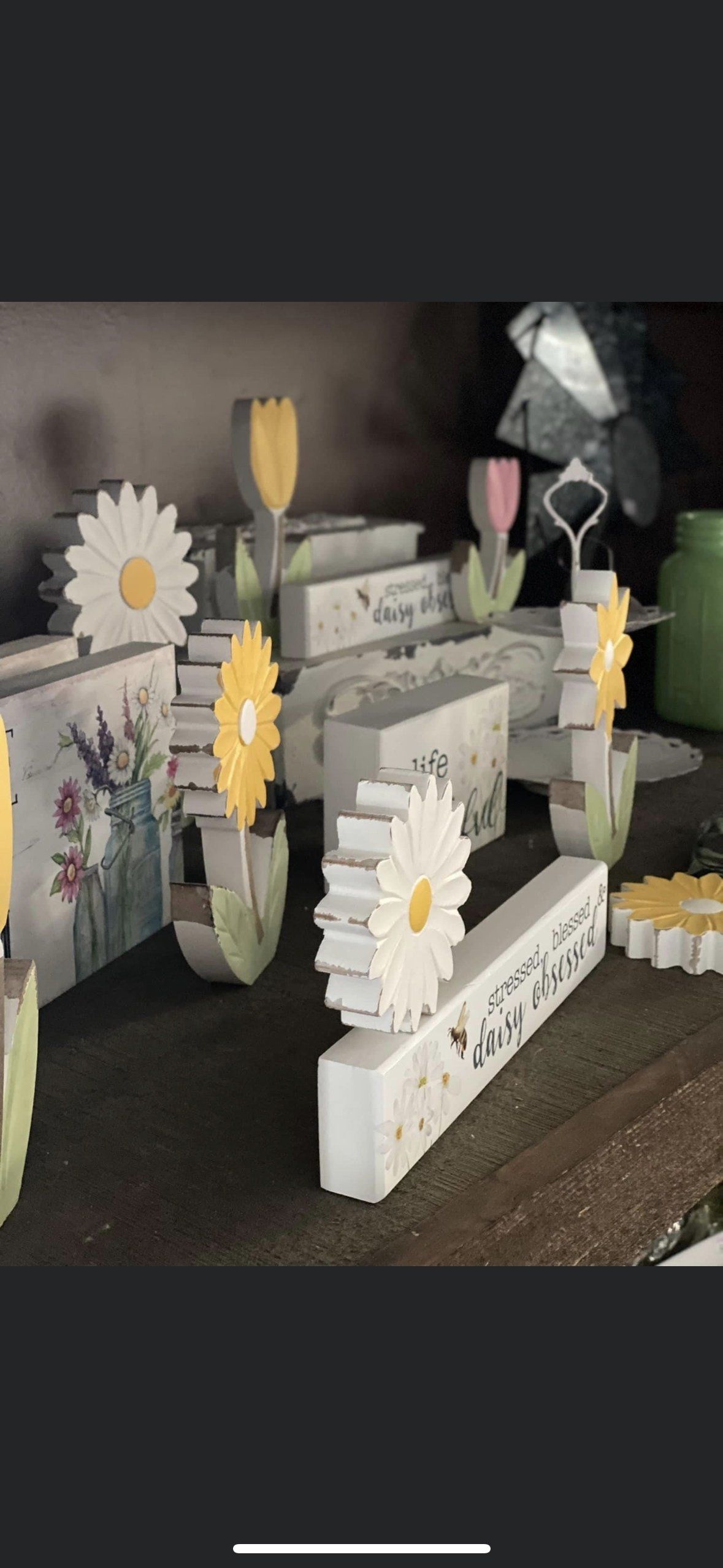 A collection of small, spring-themed wooden block decorations featuring daisies, tulips, and floral illustrations.