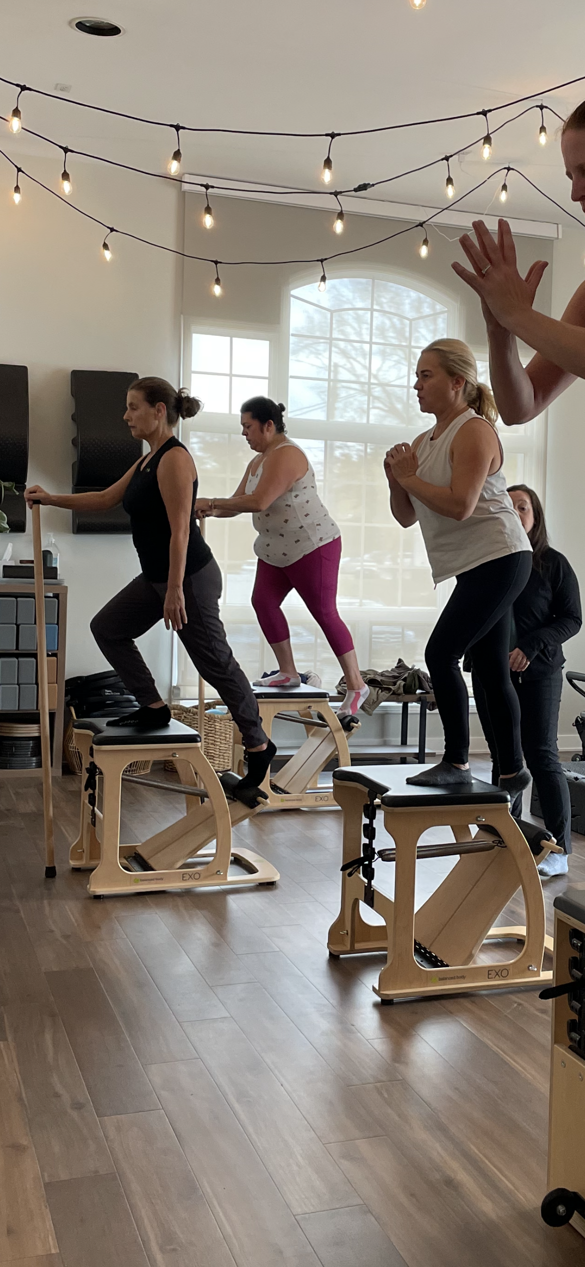 A practitioner performs a Pilates movement on a reformer.