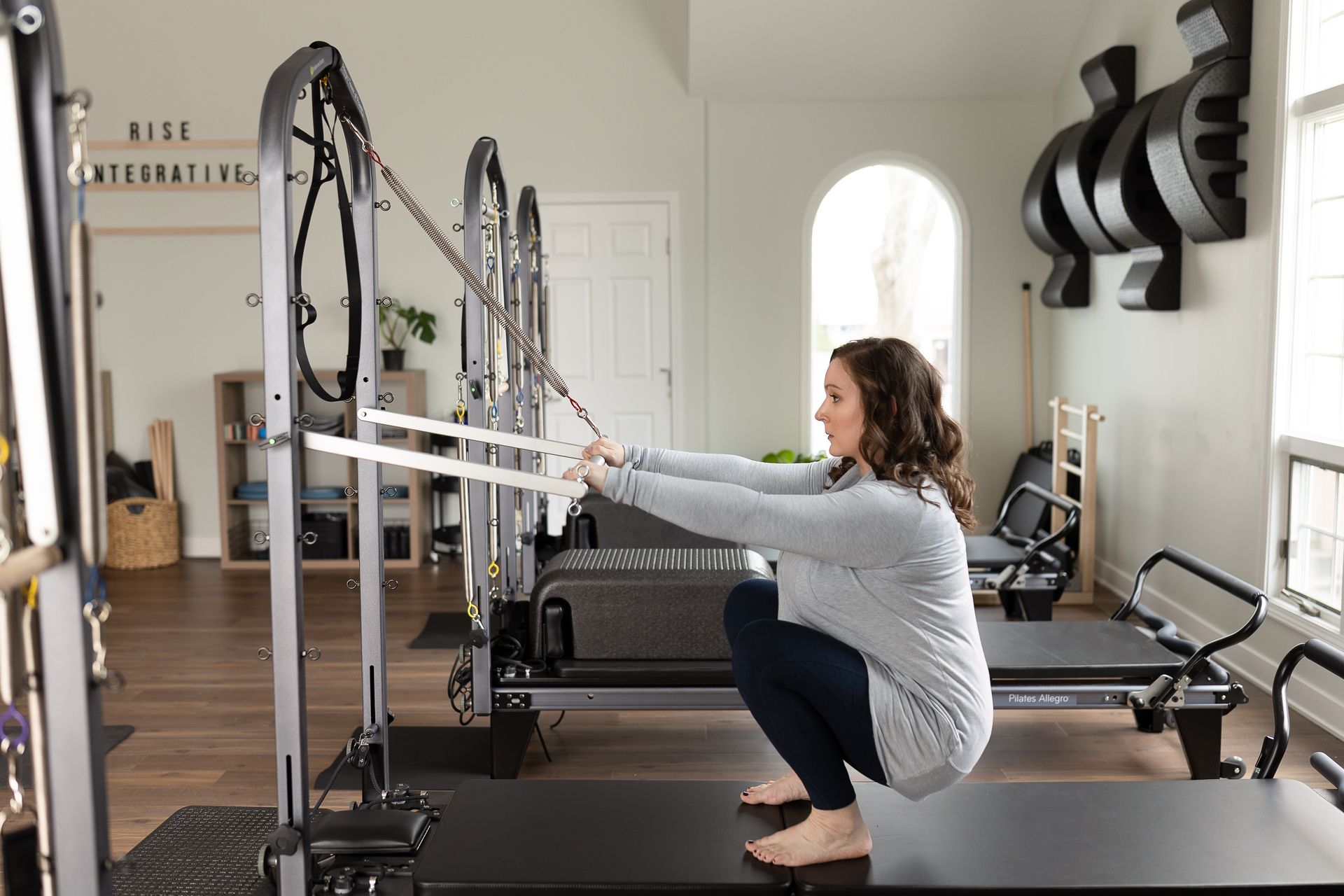Clients are doing pilates on reformers in a large room.