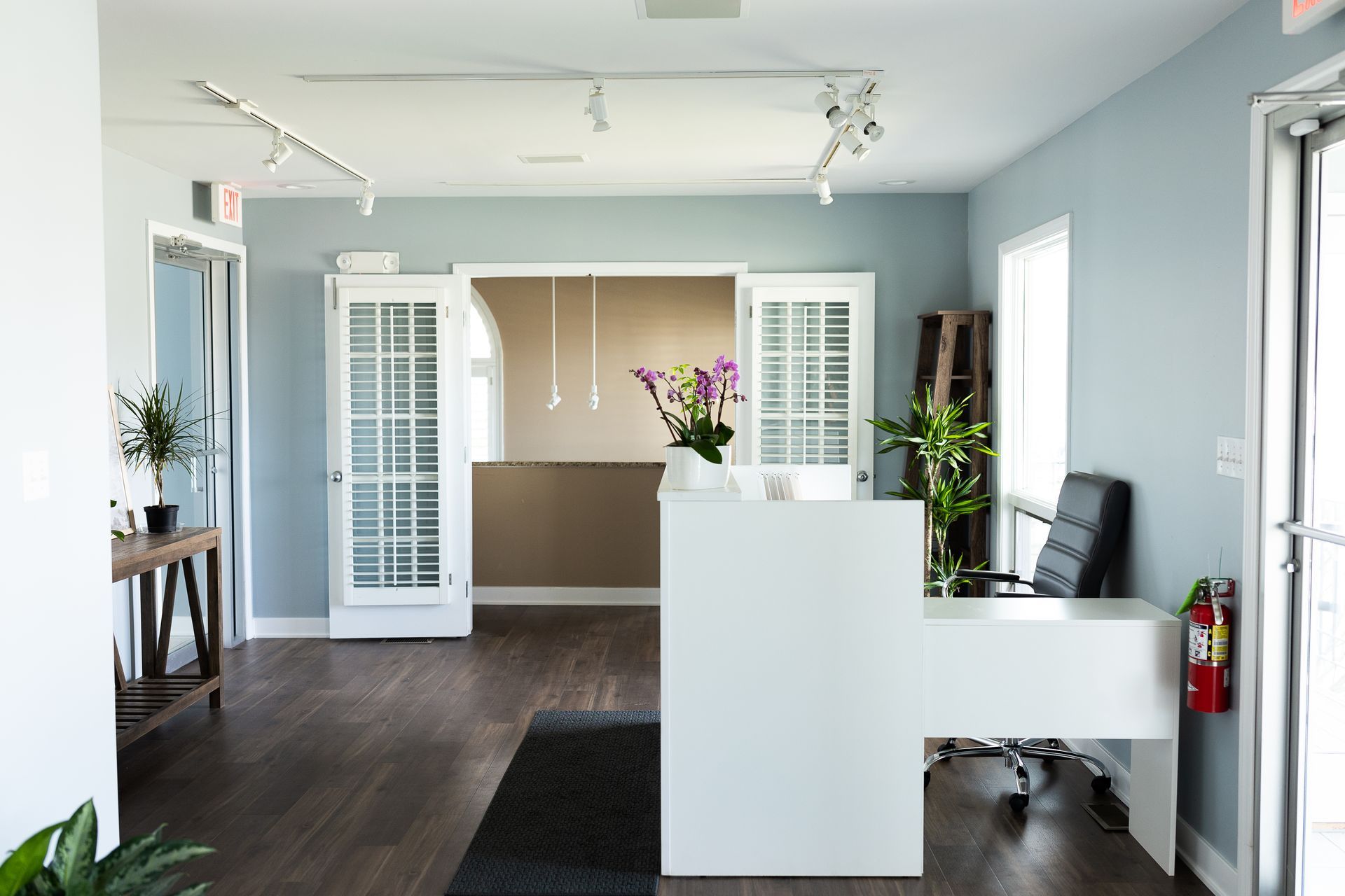 A large foyer and lobby of a pilates studio with a white desk