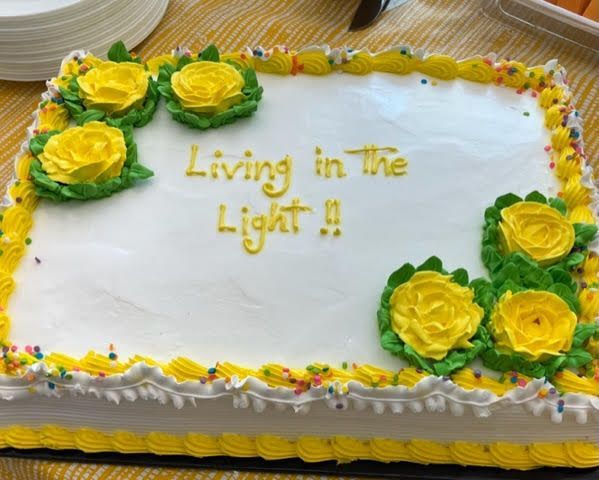 White cake with yellow frosting flowers. Written on it is