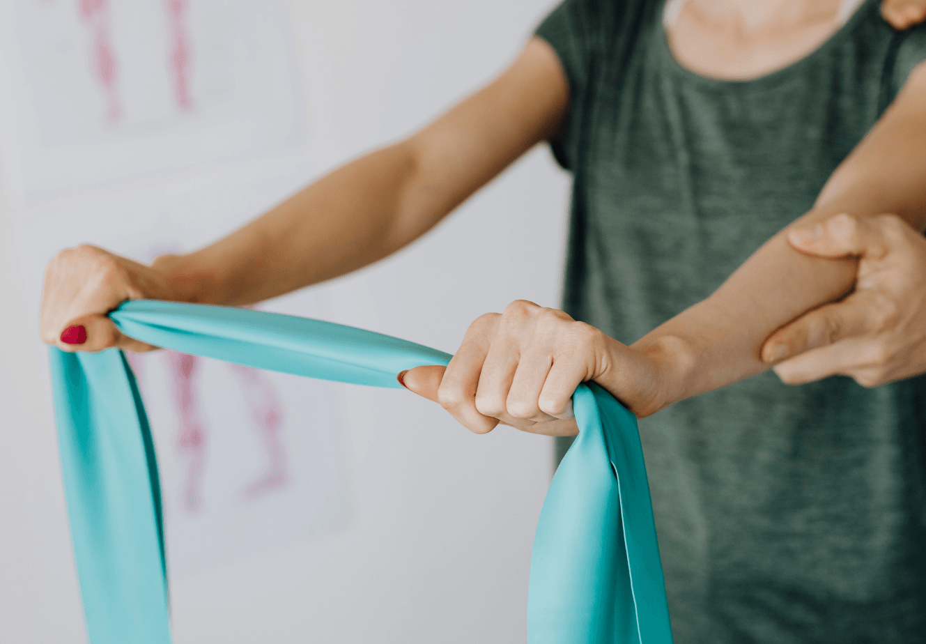Hands stretching a teal resistance band during an exercise session
