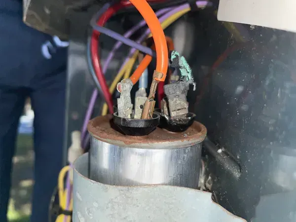 Close-up of electrical wires connected to a metal component in a machine panel