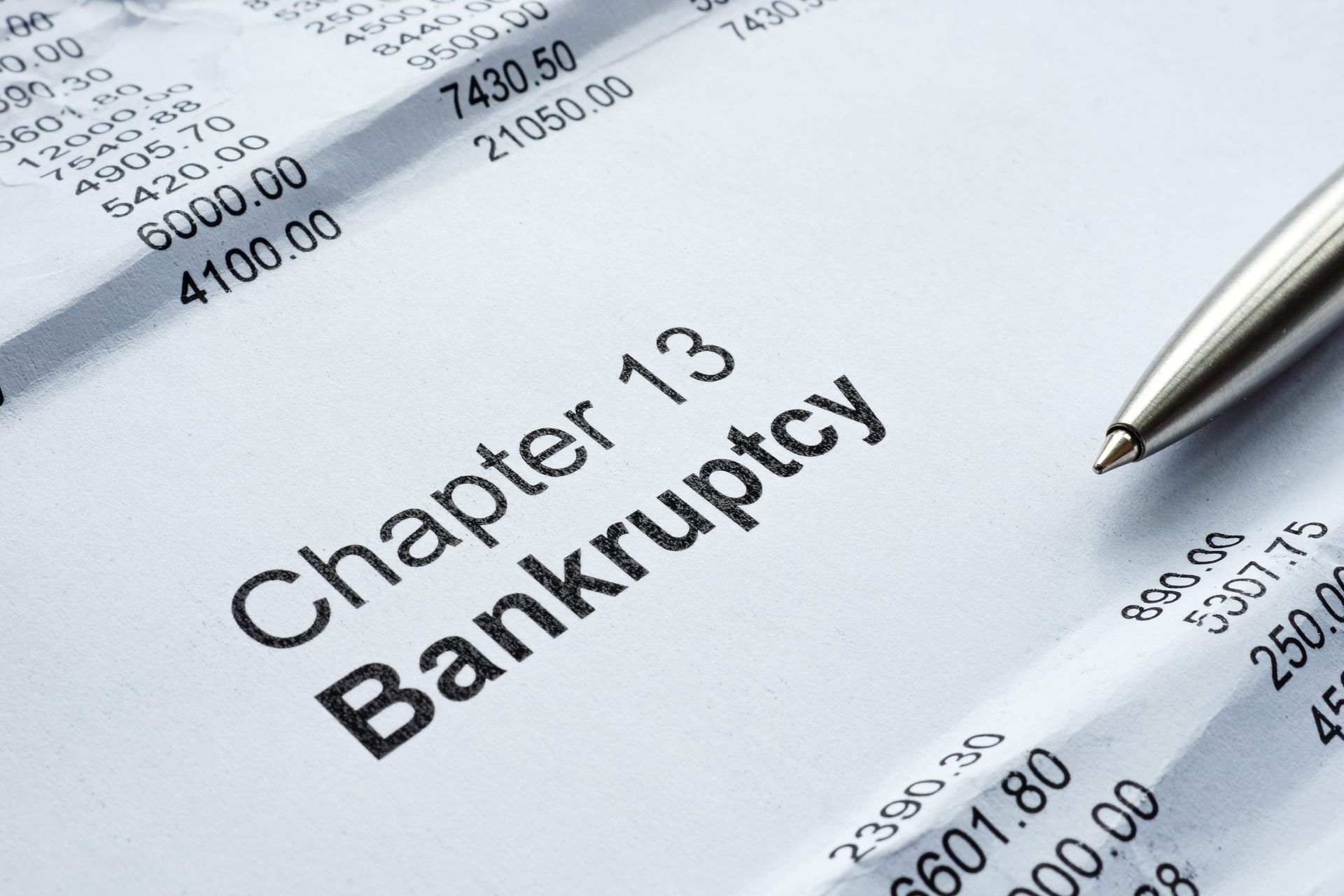 Chapter 13 bankruptcy document with a pen on financial paperwork