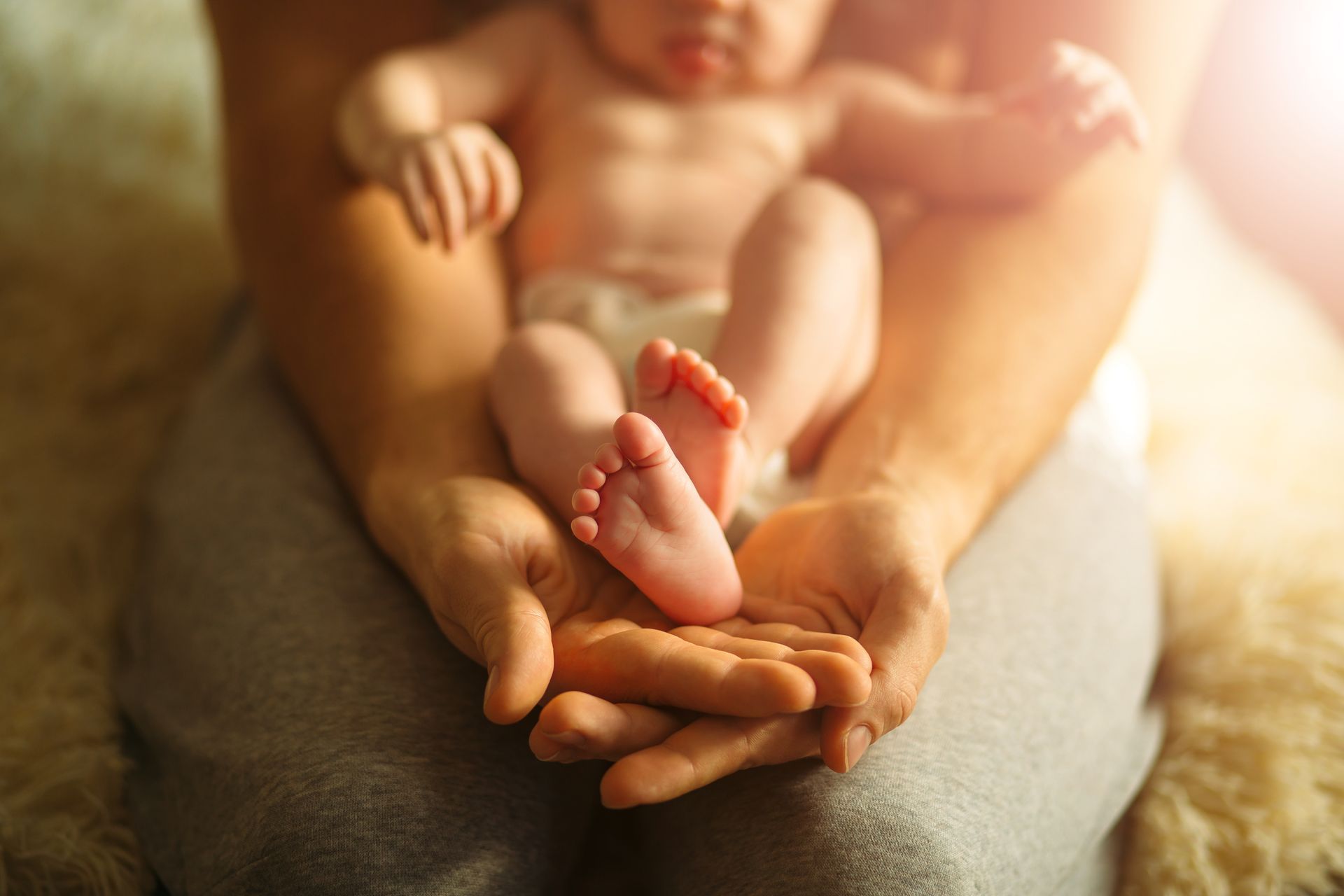 Baby's bare feet resting in a parent's hands, representing paternity in South Carolina.