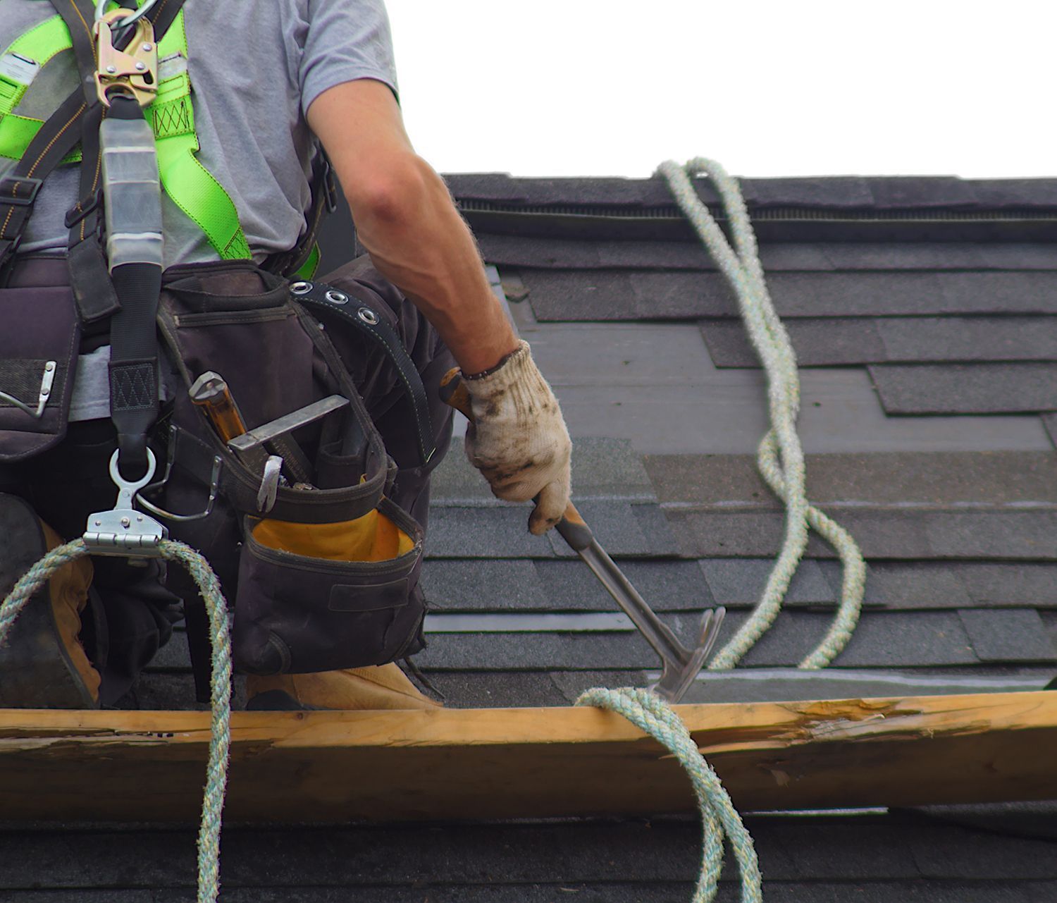 A man is working on a roof with a hammer