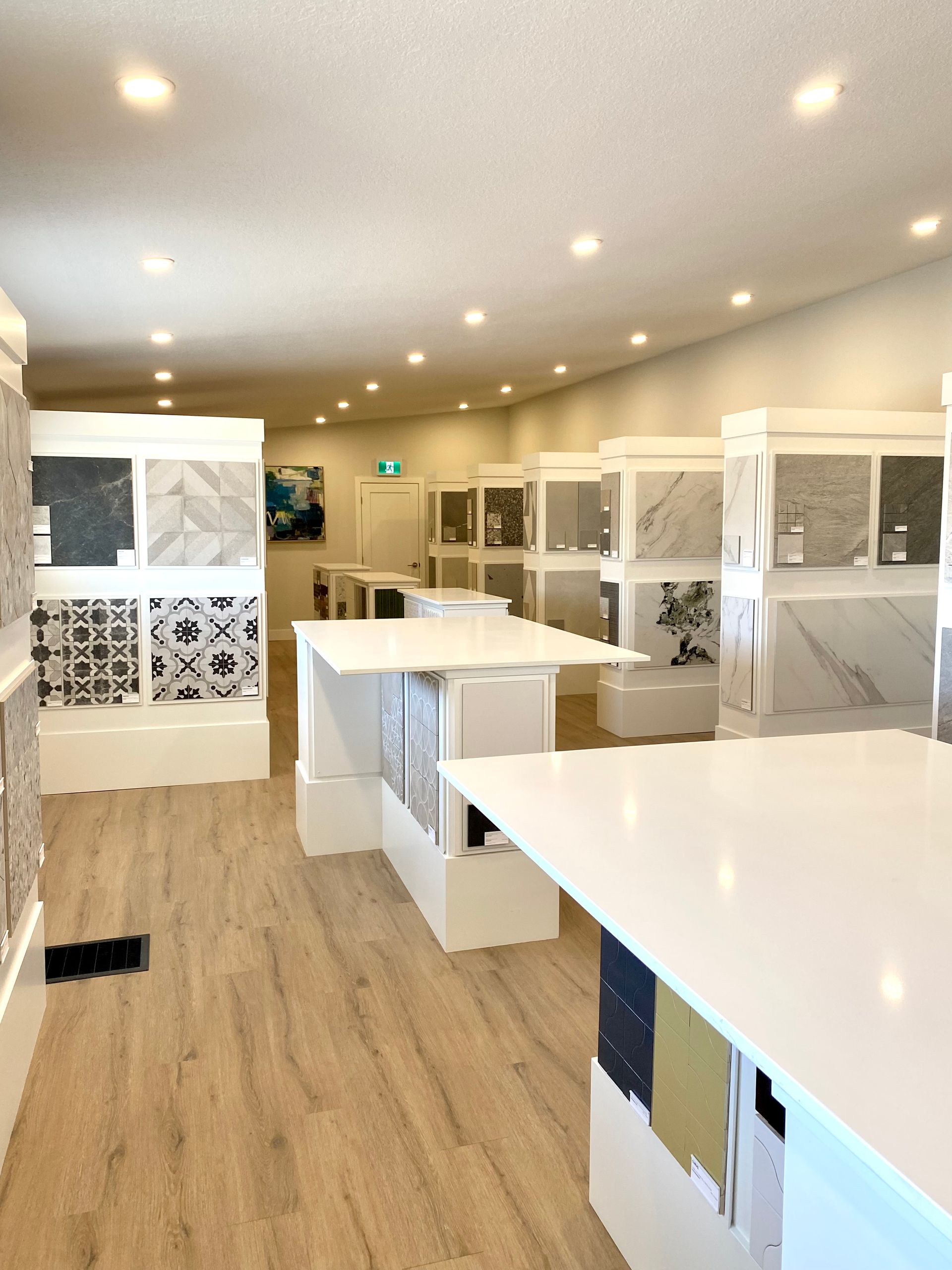 Tile showroom interior with display islands and wall panels showcasing various tile samples.