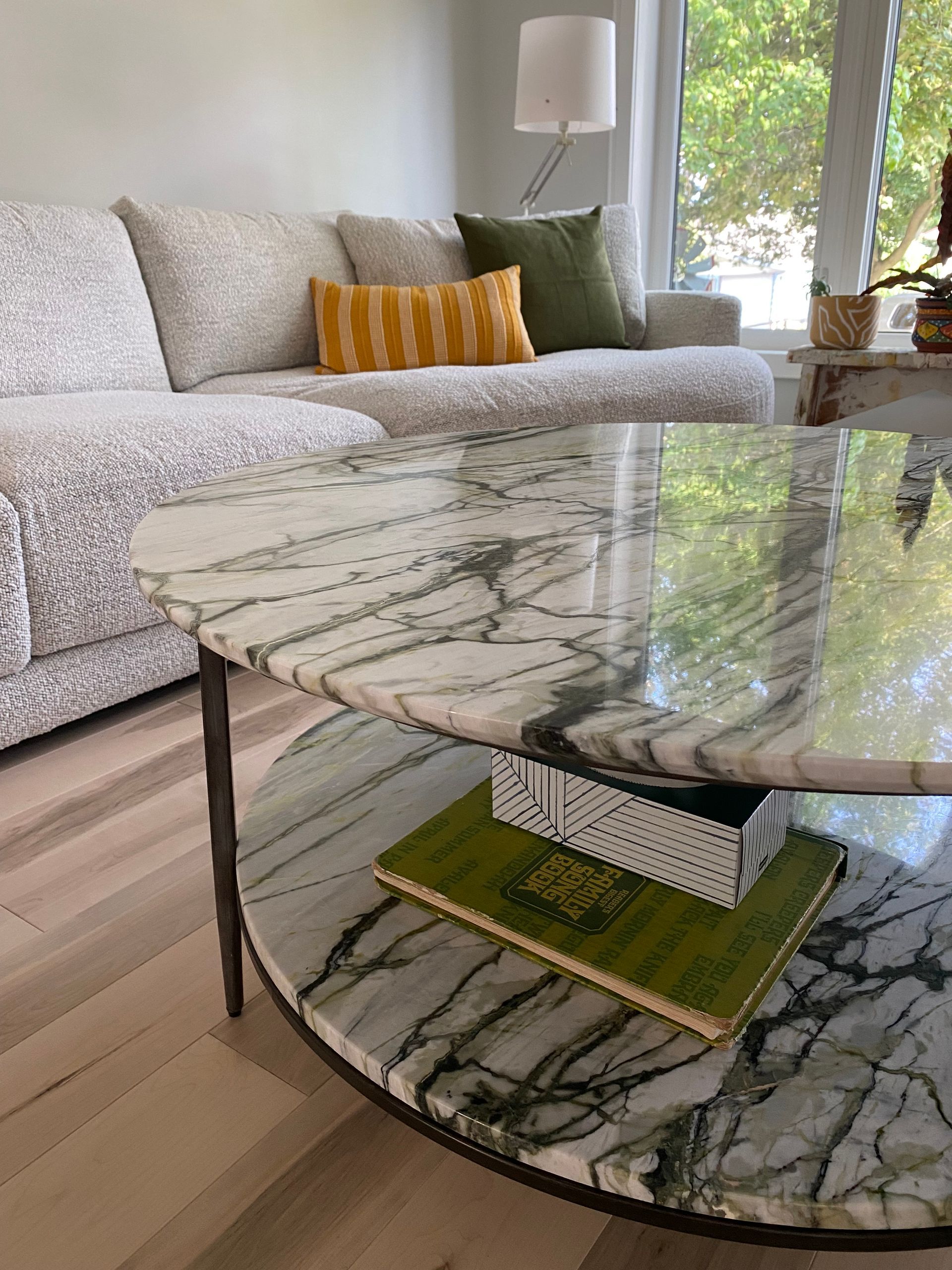 Living room with white sofa, marble coffee table, and decorative pillows.