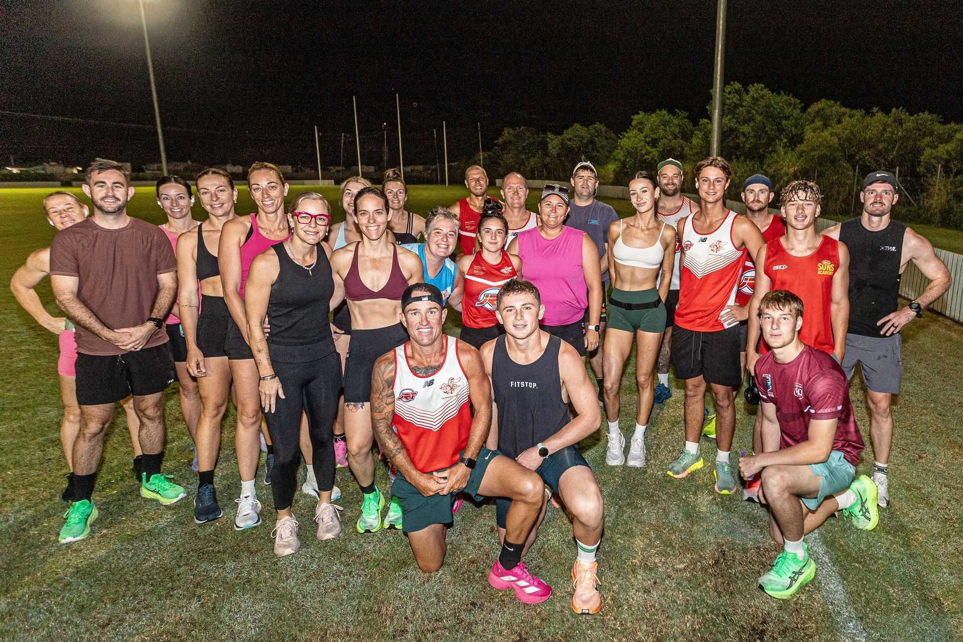 A group of senior women & mens players standing together posing for a photo at training