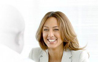 a woman in a suit is smiling and looking at the camera .