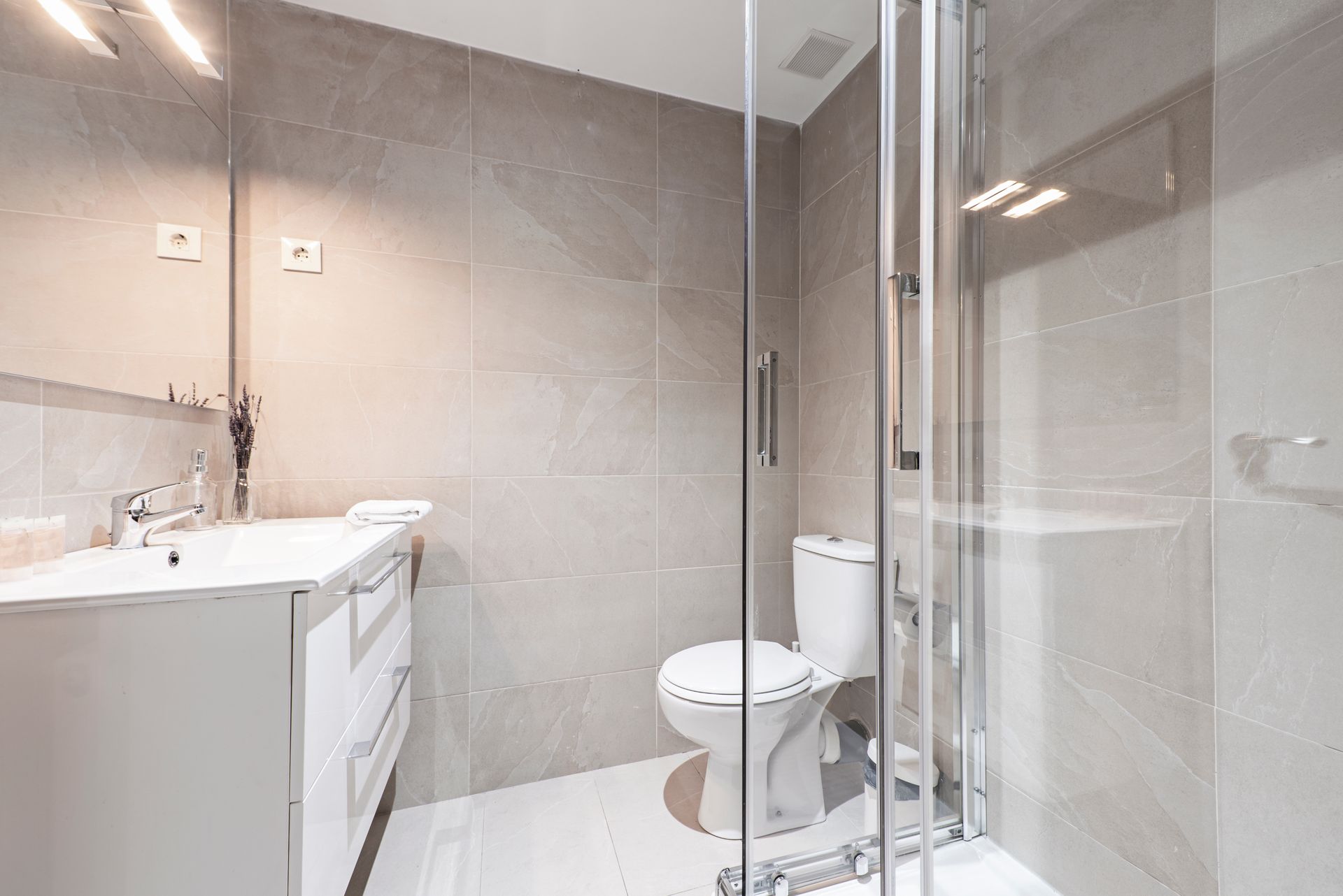 Bathroom with framed glass shower enclosure, toilet, and vanity.