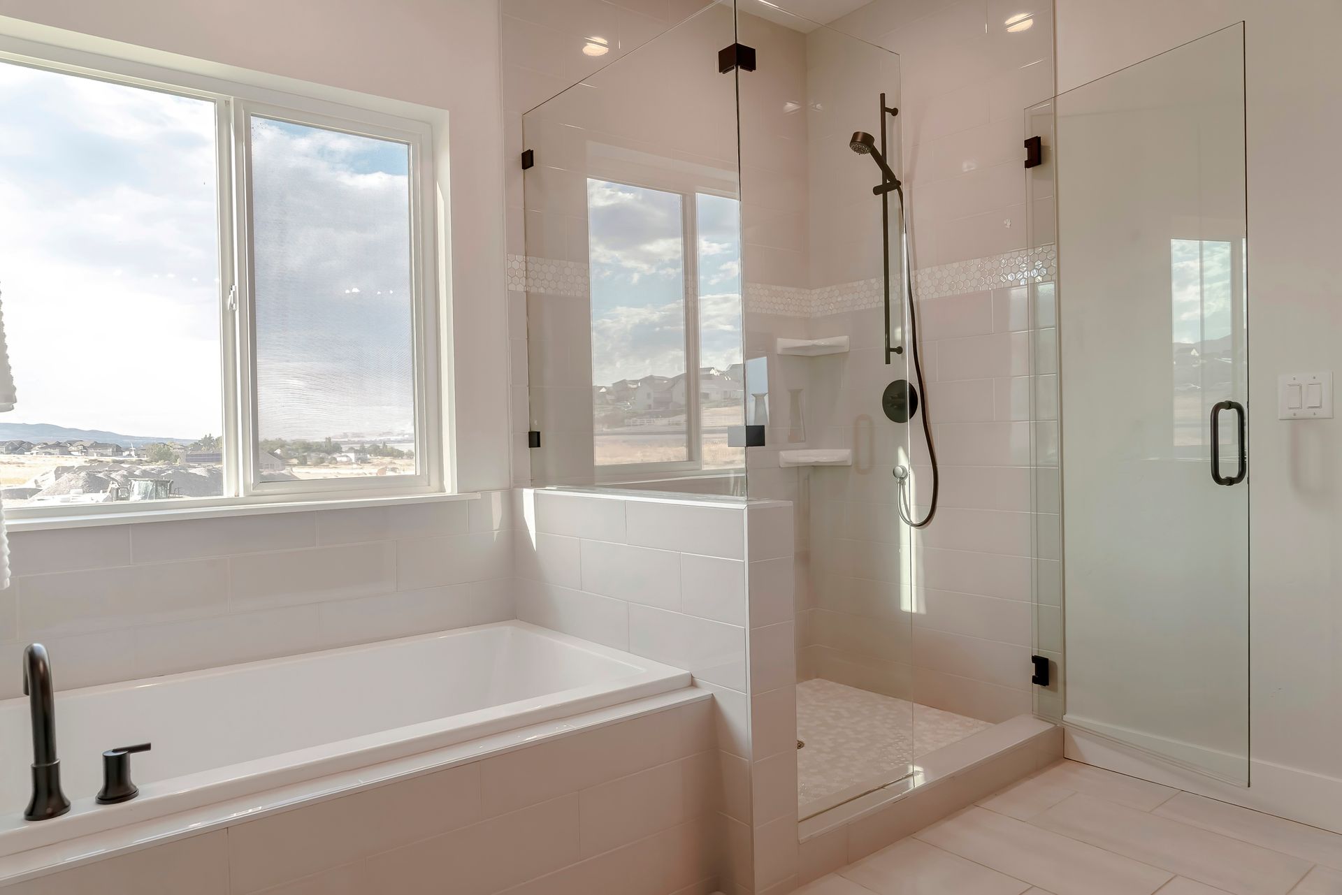 A bathroom with a tub , shower , and window.