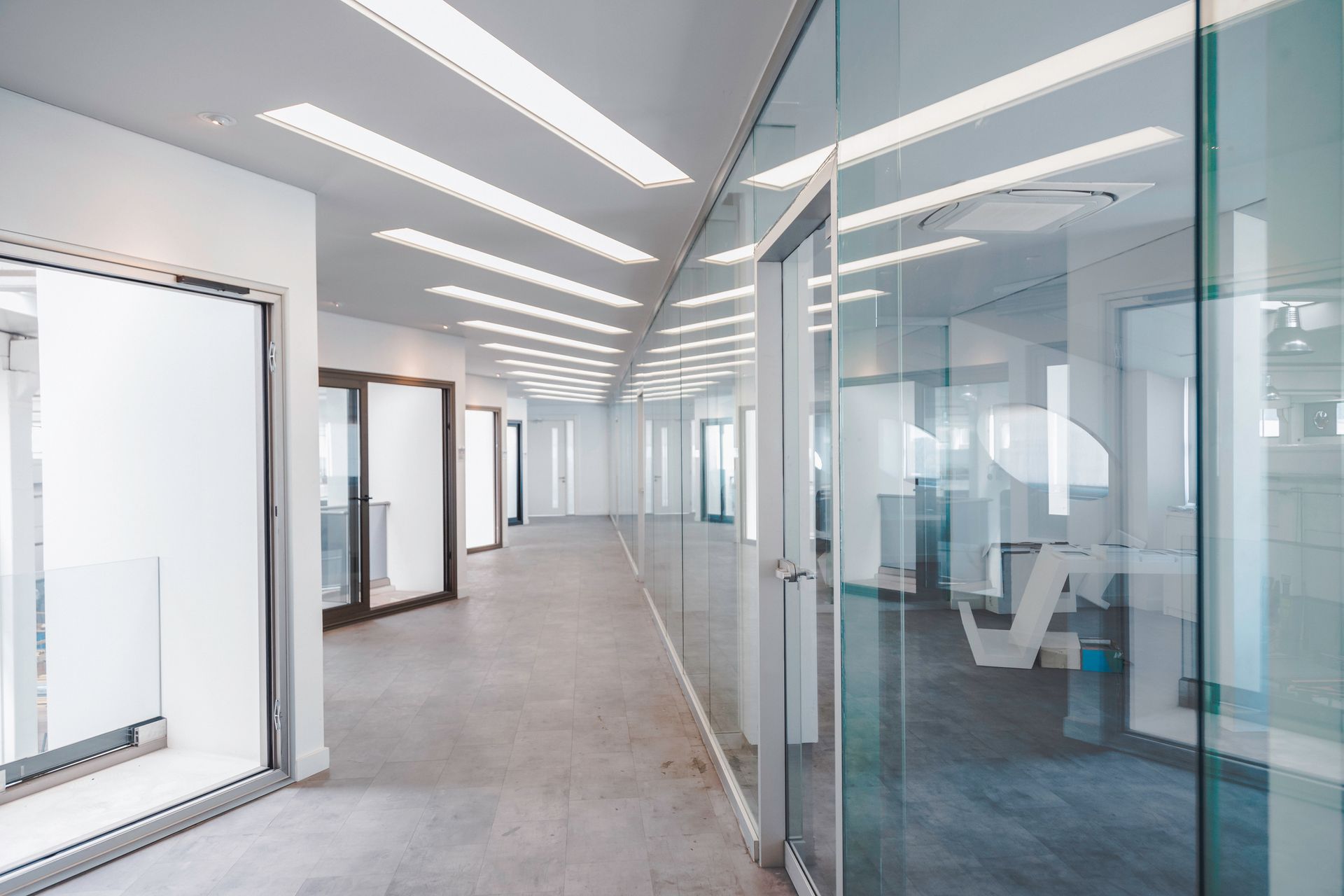A long hallway with a lot of windows and glass doors.