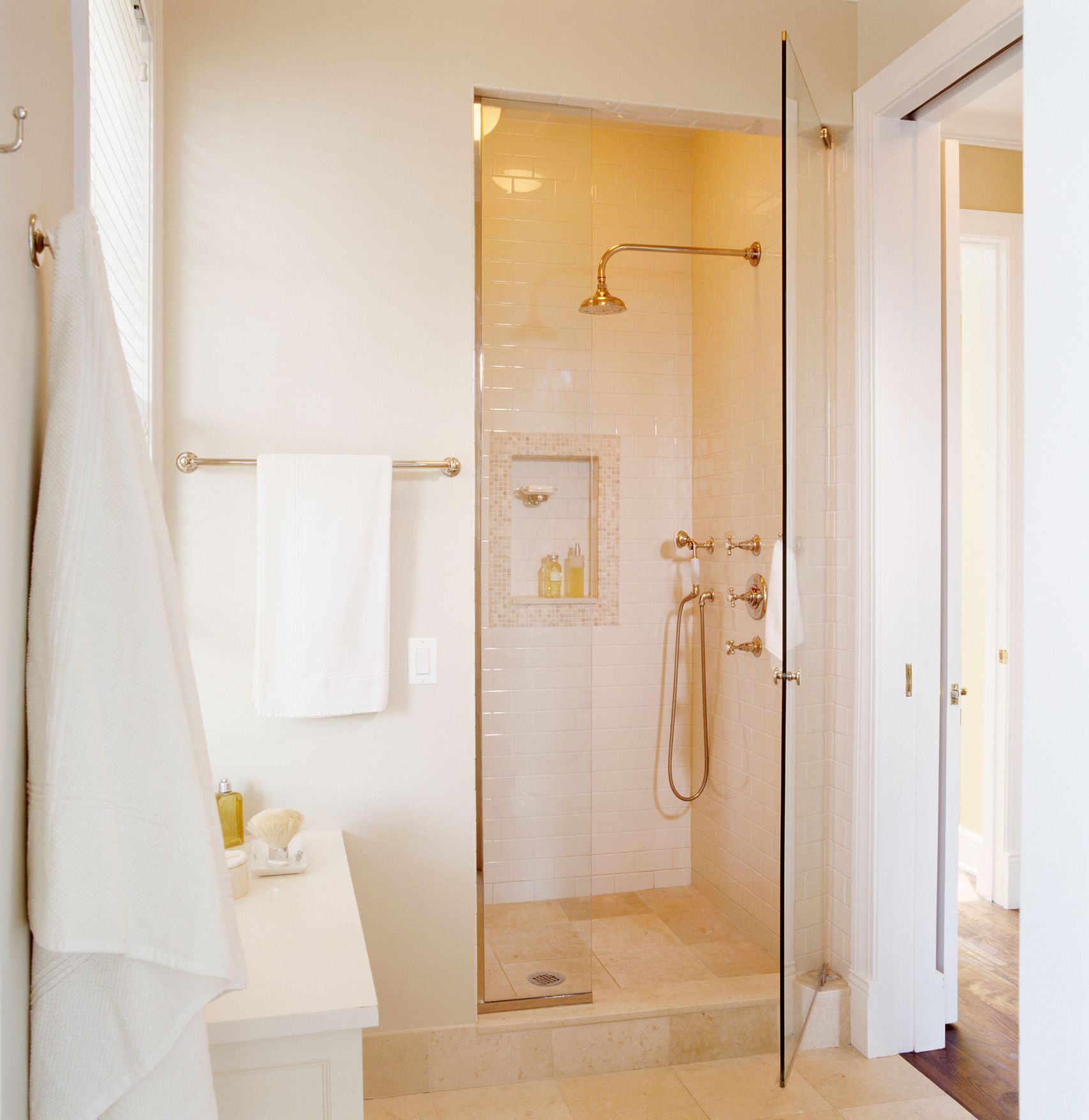 A bathroom with a walk in shower with a glass door